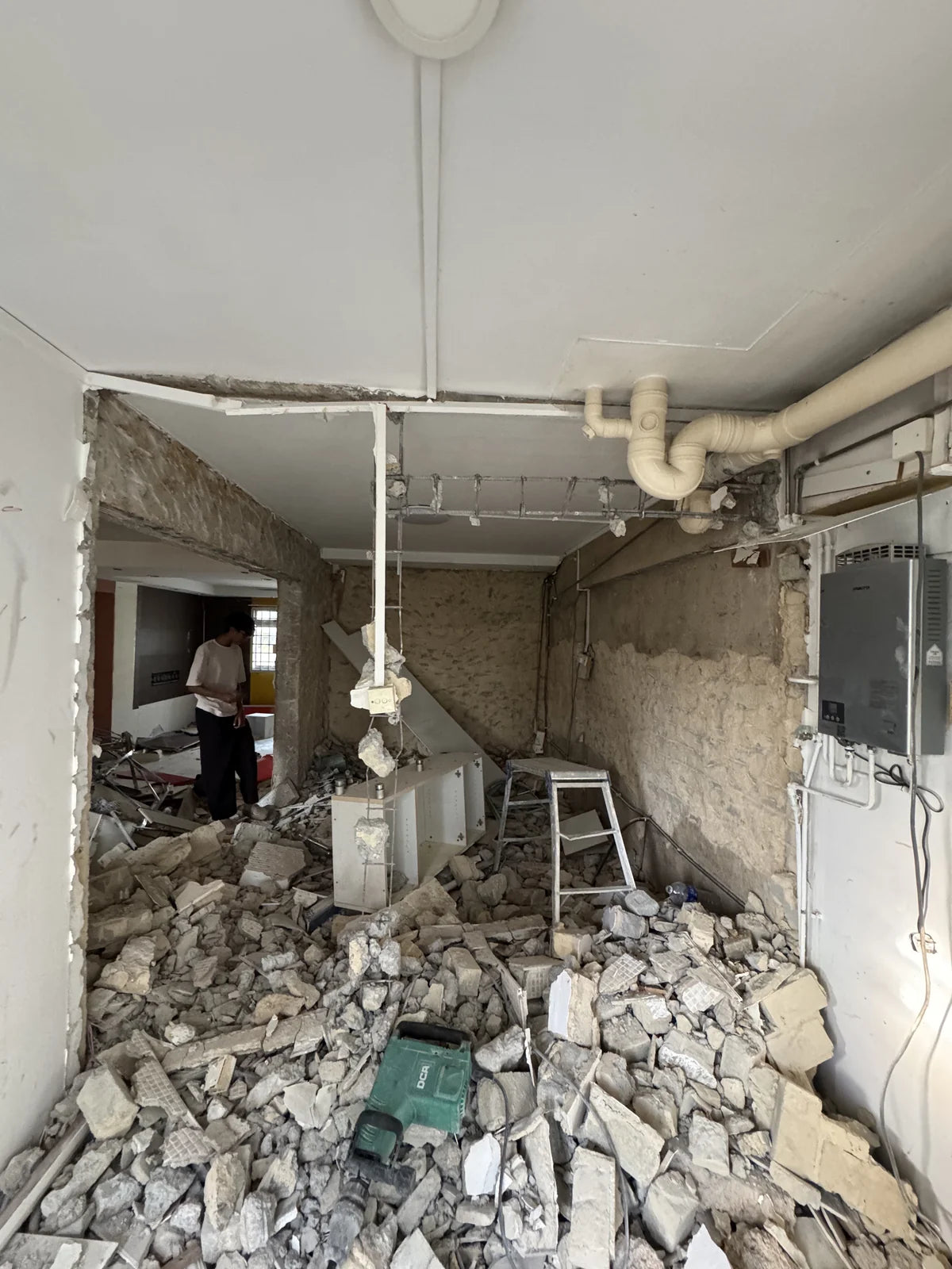 Hacked walls, rubble and exposed pipes during the demolition stage